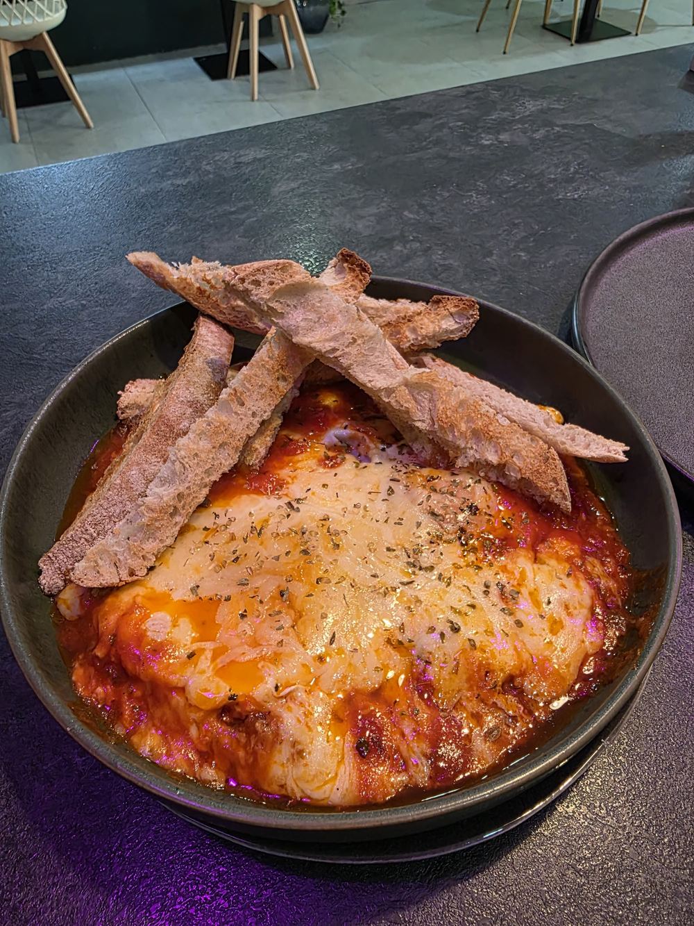 Huevos napolitanos con queso gratinado y bastones de pan