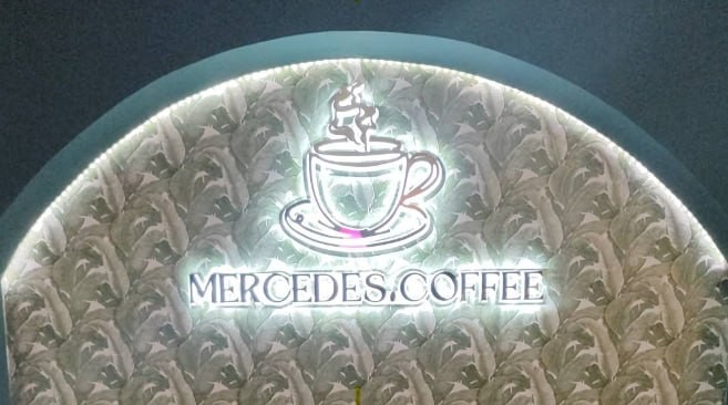 El cartel iluminado de Mercedes Coffee en la entrada